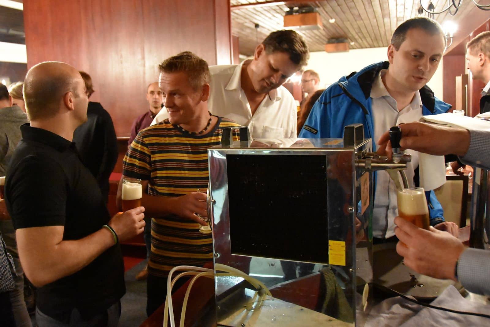Tým u výčepu čepuje pivo, které si společně uvařil